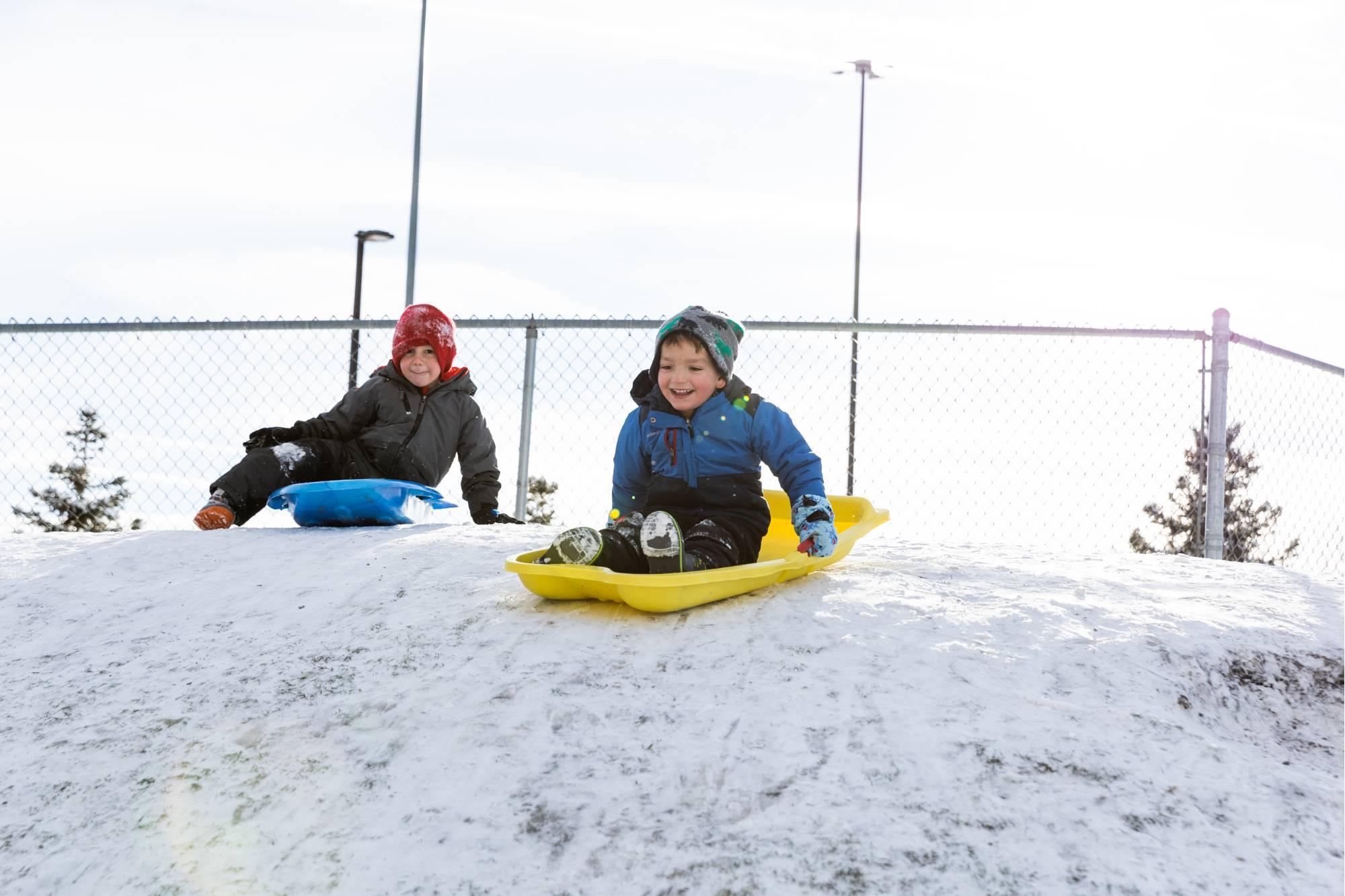 Kids playing on a sledding hill at the Children's Enrichment Center